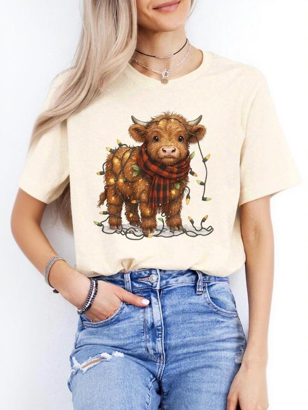 Ladies' Adorable Short - sleeve T - shirt: Beige Top with Charming Highland Cow in Winter Outfit Enjoying a Drink, a...